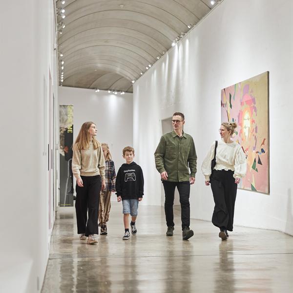 En familie går ned gennem den lange gang, der er fyldt med spændende kunstværker. De har oplevet nogle af de mange tilbud, som museet har til børnefamilier.