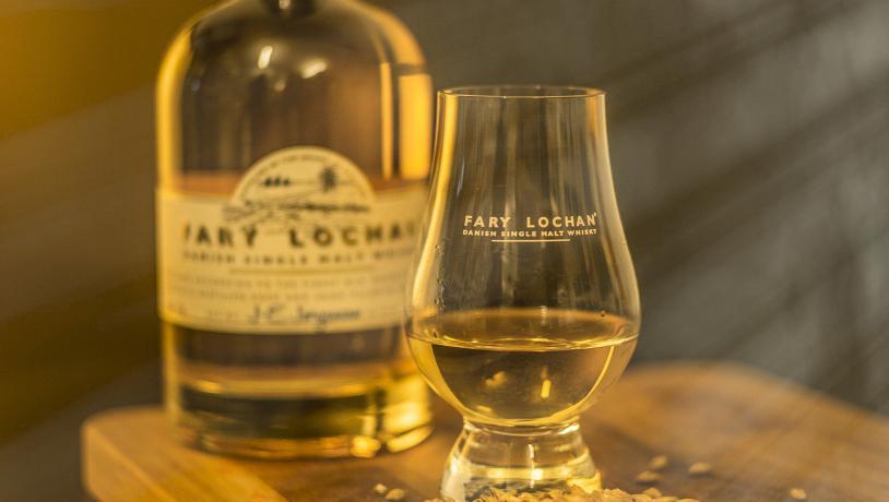 Whisky fra destilleriet Fary Lochan i et glas med en flaske bagved.