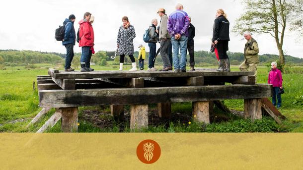 En flok mennesker prøver at stå på den rekonstruktion af Ravningenbroen, som er bygget på Ravning Enge. 