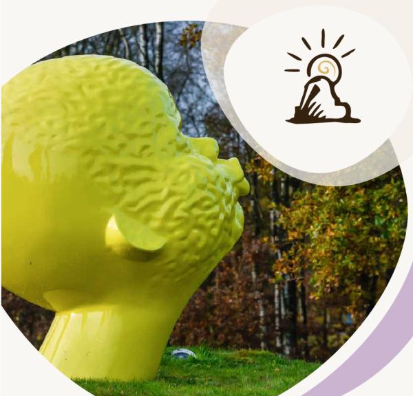 Stor gul kunstskulptur af et hoved i græslandskab, med ikon af en skulptur og sol øverst til højre.